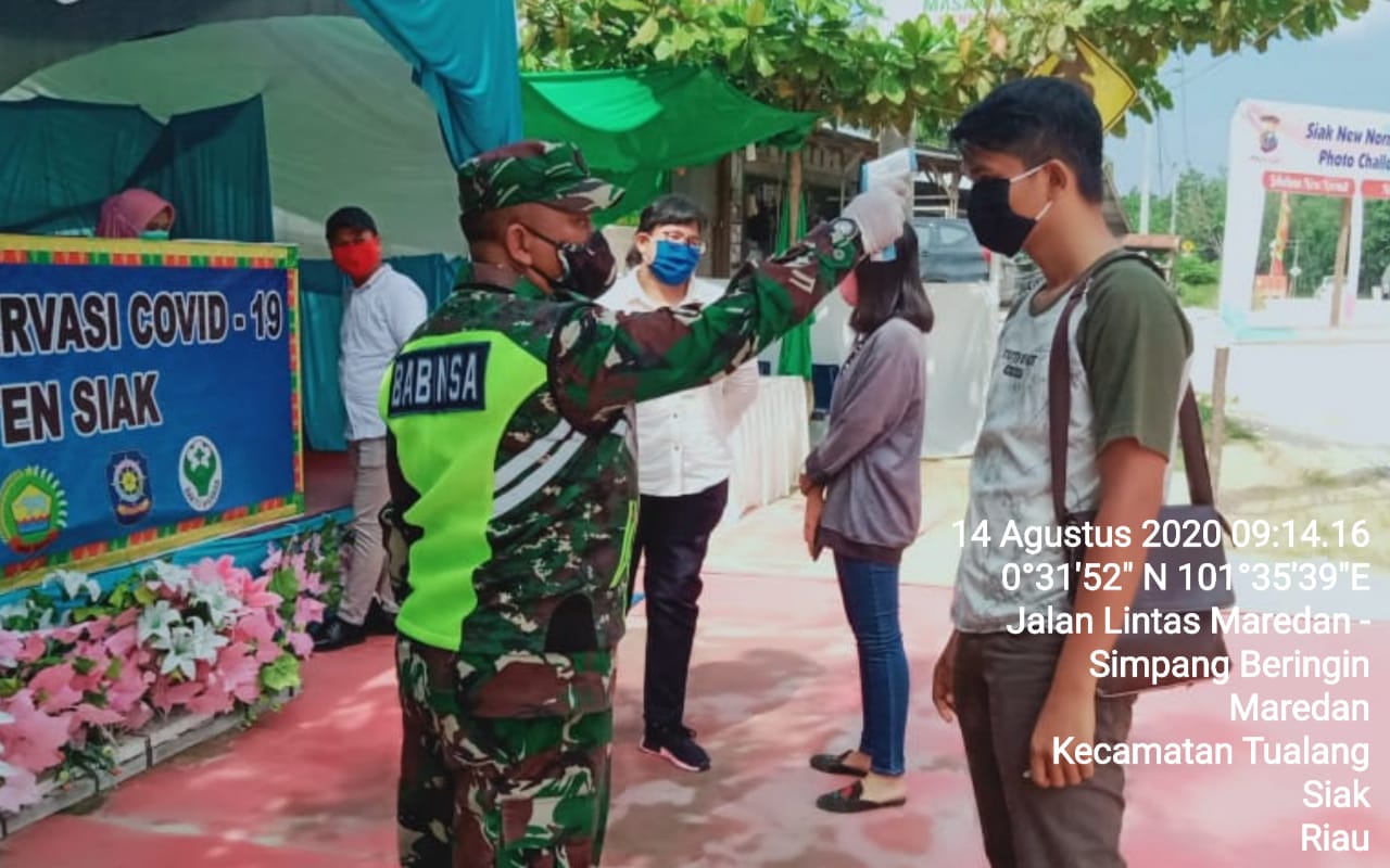 Cegah Covid-19, Serda Uuk Sudarijanto Cek Suhu Pengendara Yang Hendak Masuk Siak