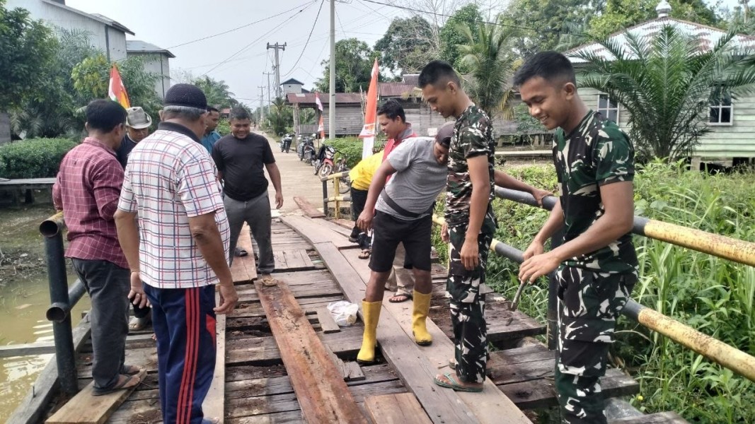 Perkuat Kemanunggalan TNI dan Rakyat, Satgas TMMD ke-129 Kodim 0313/KPR dan Warga Gotong Royong Perbaiki Jembatan jalan Desa.