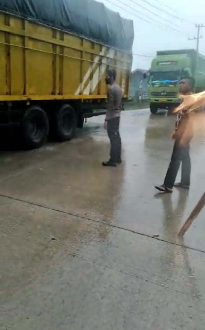 Dibawah Guyuran Hujan, Kapolsek Batang Gansal Atur Arus Lalu Lintas