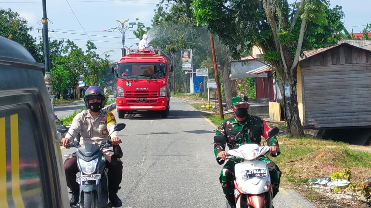 Lakukan Penyemprotan Disinfektan, Danramil Tualang Beri Edukasi ke Masyarakat Tentang Prokes