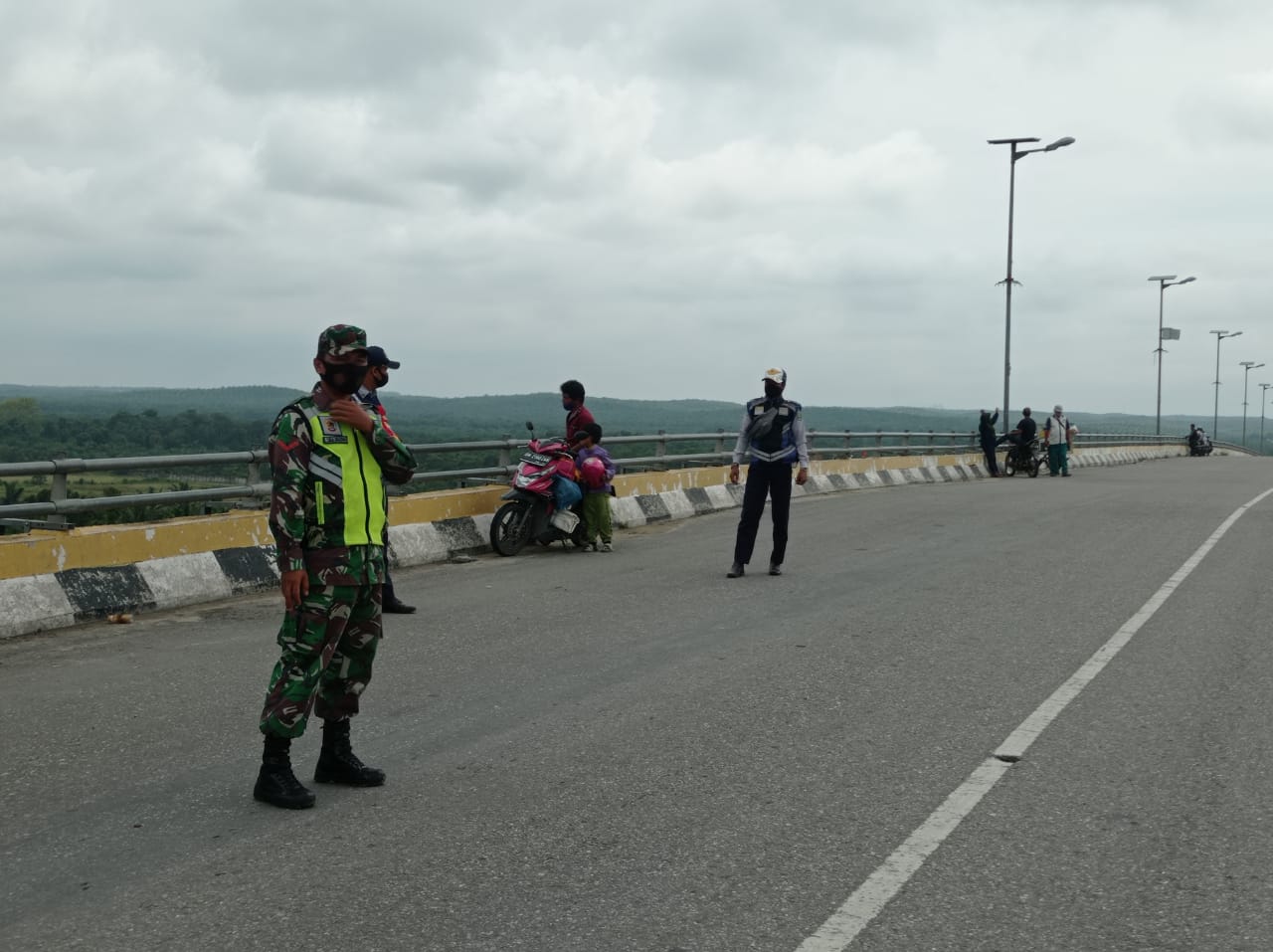 Bersama Dishub, Kopda L Sigalingging Lakukan Pengaturan Lalin di Jembatan SSK