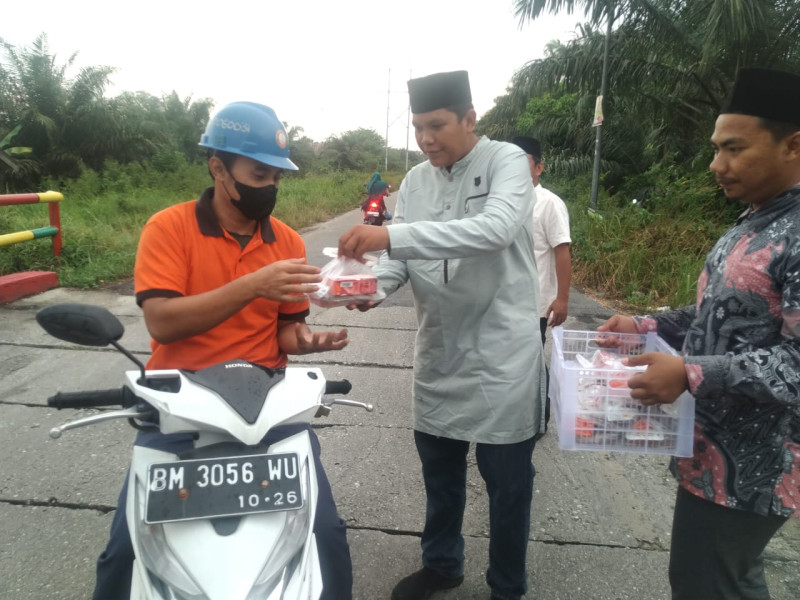 Meski Gerimis, Arizal Tetap Bagi Takjil Di Jembatan Zaitun