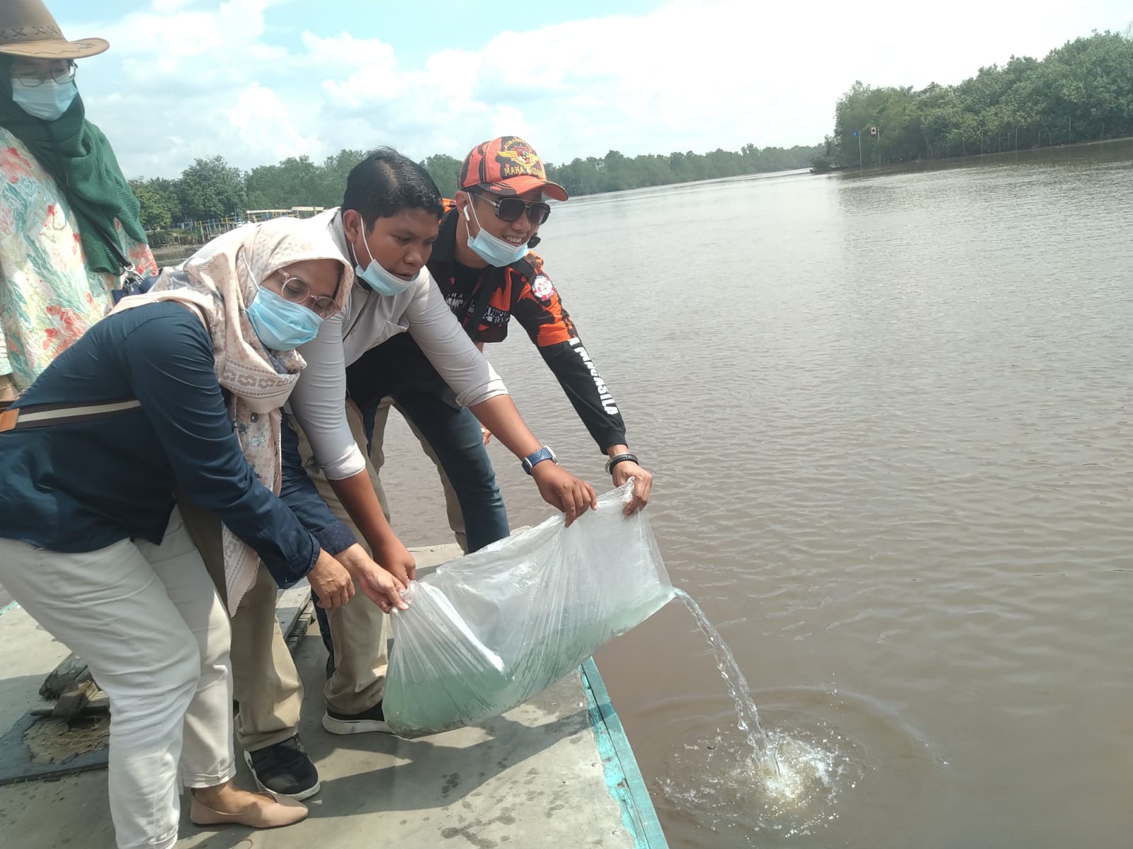 Tokoh Pemuda Arizal, PWI dan Ormas PP Siak Tabur Bibit Ikan Patin di Sungai Siak